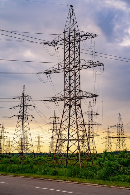 Tour électrique haute tension. Silhouette à l'heure du coucher du soleil. Pylônes électriques sur fond de coucher de soleil. Mise au point sélective