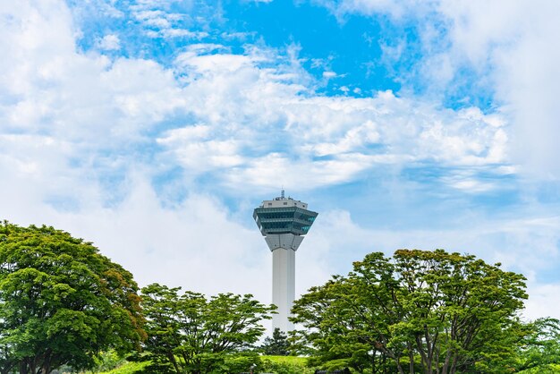 Photo la tour goryokaku en été, un jour ensoleillé, des nuages blancs et un ciel bleu. la tour est sur le pont de l'observatoire.