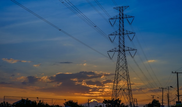 Tour à haute tension sur fond de coucher de soleil.