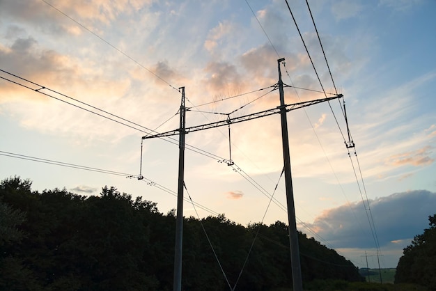 Tour haute tension avec lignes électriques au coucher du soleil