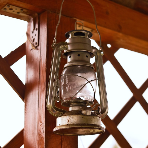 Tour de lanterne à huile de kérosène vintage suspendu à un pilier en bois. Ancienne lampe rétro antique.