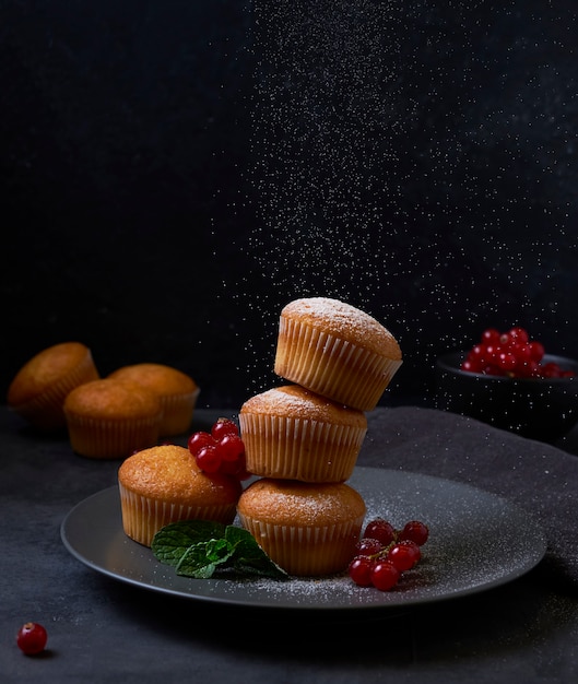 Tour de muffins frais avec des baies en plaque sur fond noir