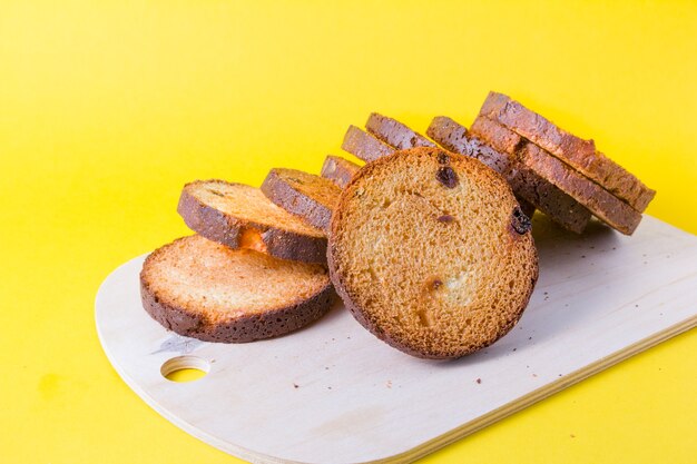 Une tour de pain rond cuit de biscottes sur fond jaune