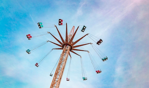 Photo un tour de parc d'attractions sur un carrousel céleste contre le ciel au coucher du soleil