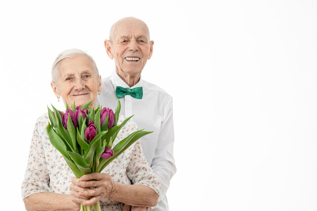 Tour de taille portrait de l'heureux couple souriant avec un bouquet