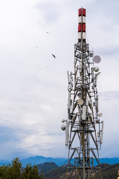 Tour de télécommunication avec antennes. Transmetteur d'antenne de communication sans fil avec des montagnes en arrière-plan. Banque d'images.