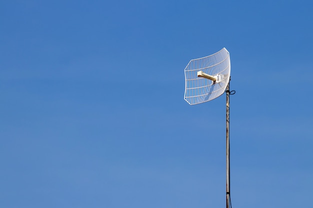 Tour de télécommunication avec ciel bleu et nuages blancs, technologie de communication de pôle satellite.