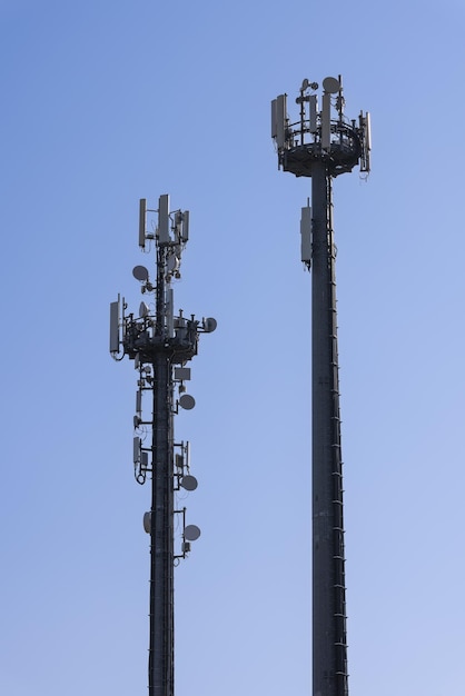 Tour de télécommunications antennes cellulaires répéteurs ciel bleu clair photo verticale