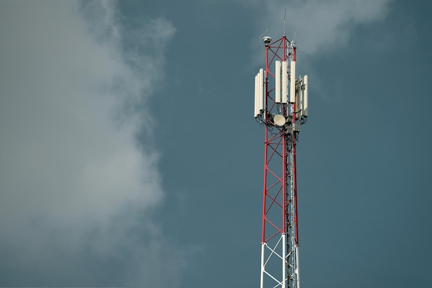 Une tour de téléphonie cellulaire avec un ciel noir derrière elle.