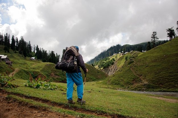 Tourisme mâle avec sac à dos se dresse près de la rivière