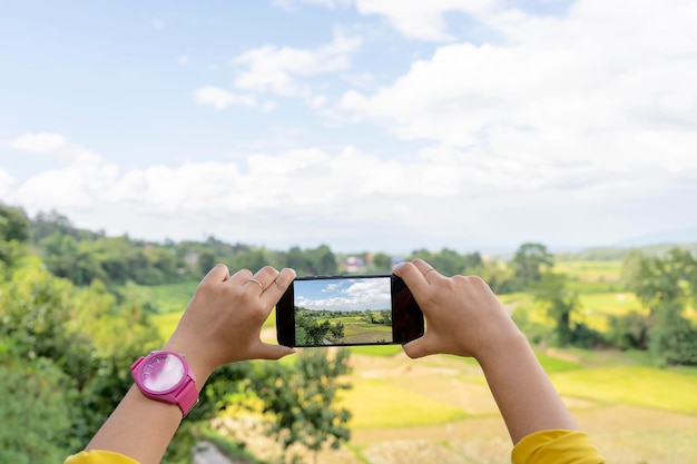 Tourisme naturel en Thaïlande dans le nord Une femme qui utilise un smartphone pour prendre des photos pour enregistrer l'histoire de son voyage