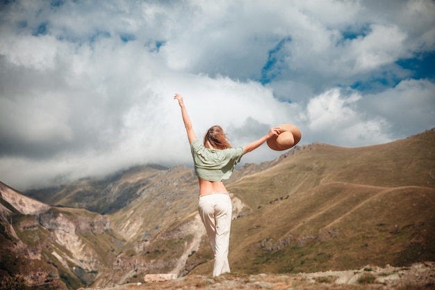 Tourisme en plein air lifestyle femme touriste posant sur les montagnes et le ciel nuageux.