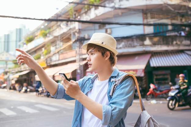 Tourisme et technologie. Concept de carte en ligne. Jeune homme de backpacker voyageant à l'aide d'une tablette numérique en plein air.