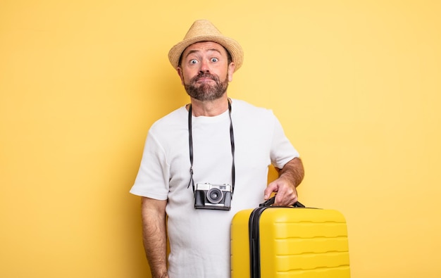 Touriste d'âge moyen haussant les épaules, se sentant confus et incertain. concept de voyage