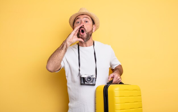 Touriste d'âge moyen se sentant heureux, donnant un grand cri avec les mains à côté de la bouche. concept de voyage