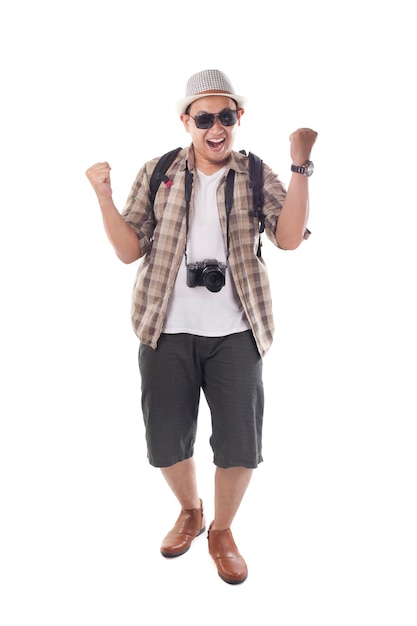 Touriste asiatique avec un chapeau, des lunettes de soleil noires, une caméra montrant un geste de victoire heureux.