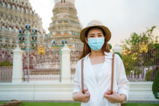 Touriste asiatique avec masque voyage à Wat Arun à Bangkok, Thaïlande.