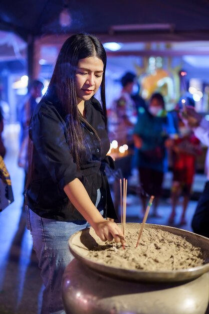 Touriste asiatique rendre hommage avec de l'encens à Bouddha pour le culte avec foi à la statue de Bouddha dans le temple thaïlande croyance au bouddhisme