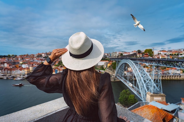 Touriste bénéficiant d'une belle vue sur la vieille ville de Porto avec la rivière et le célèbre pont de fer