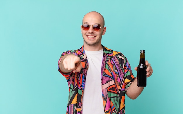 Touriste avec bière touriste homme pointant la caméra avec un sourire satisfait, confiant et amical, vous choisissant