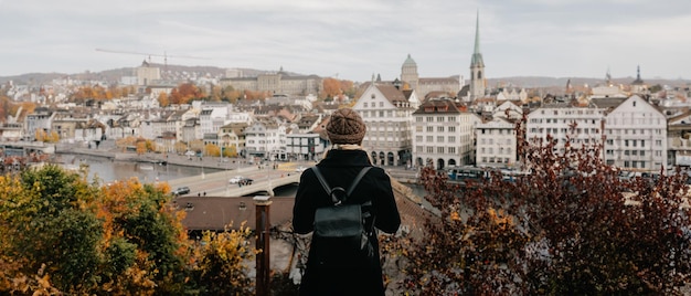 une touriste en chapeau chaud et en manteau avec un sac à dos marchant à l'automne froid dans la ville d'Europe