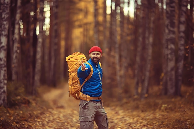 touriste dans la forêt d'automne sur une route forestière, une aventure dans la forêt d'octobre, un homme randonnée paysage d'automne