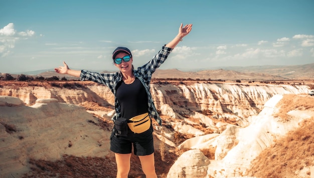 Touriste debout avec les mains levées sur le canyon en cappadoce fond turquie