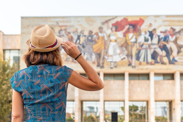 Photo une touriste avec le dos tourné à l'entrée du musée historique national de la place skanderbeg à tirana albanie