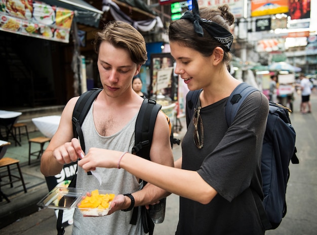 Touriste essayant de la mangue avec du riz gluant