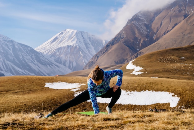 Une touriste fait du sport sur fond de montagnes