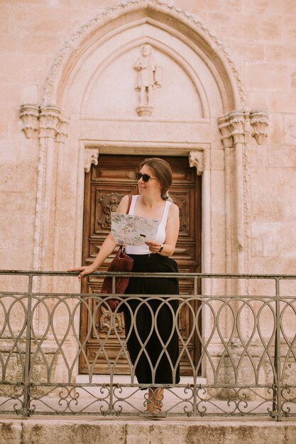 Touriste féminine avec un plan de la ville près de l'église San Francesco d'Assisi à Ostuni Italie