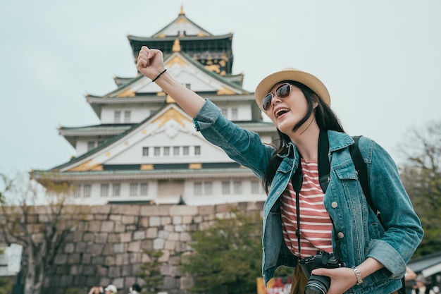 Touriste de femme asiatique confiante levant le poing vers le haut