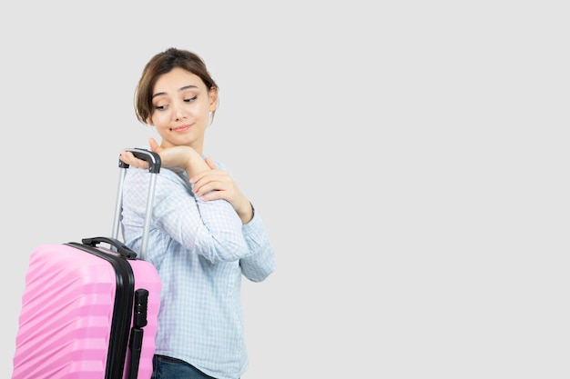 Touriste de femme debout et tenant une valise de voyage rose. photo de haute qualité