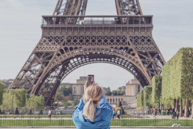 Touriste fille prenant des photos de la Tour Eiffel.