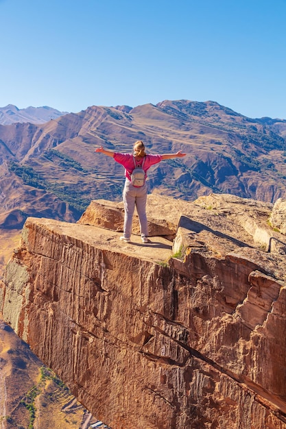 Touriste de fille sur un rebord extrême dans la roche Langue de Troll