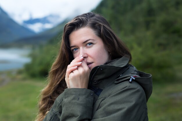 Touriste fille souffle sur ses mains en les réchauffant le matin froid dans les montagnes