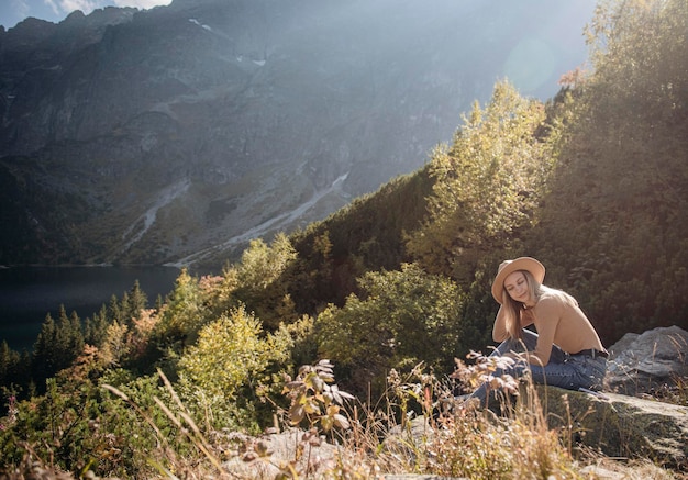 Touriste de jeune femme assise sur le sommet de la montagne et de belles montagnes