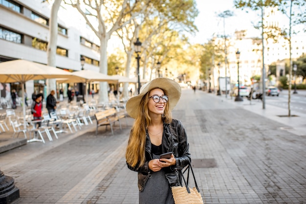 Touriste de jeune femme dans le chapeau marchant sur le boulevard piétonnier célèbre dans la ville de Barcelone