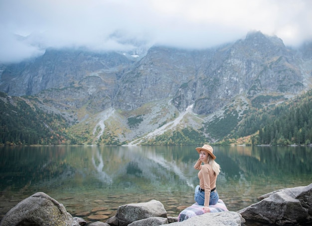 Touriste de jeune femme s'asseyant sur la crête de montagne et de belles montagnes