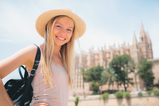 Touriste de jeune fille souriante attrayante explorant la nouvelle ville en été