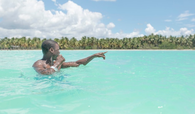 Touriste mâle noir dans l'eau de mer