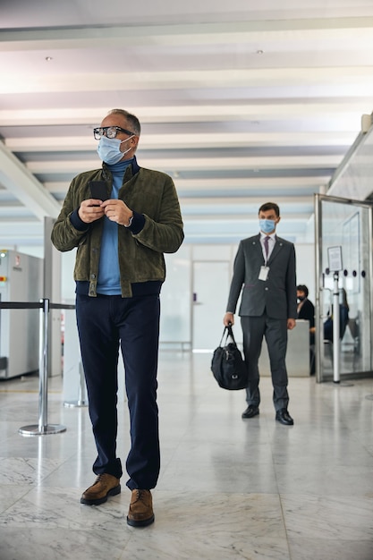 Touriste masculin debout au terminal de l'aéroport