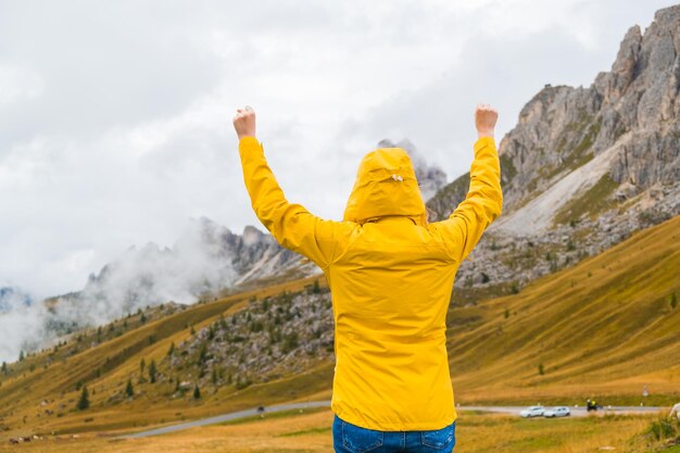 Un touriste masculin heureux écarte les mains et profite des Alpes