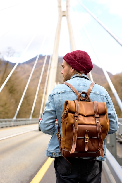 Touriste masculin marchant seul sur le pont Mode de vie de voyage, vacances en plein air, seul