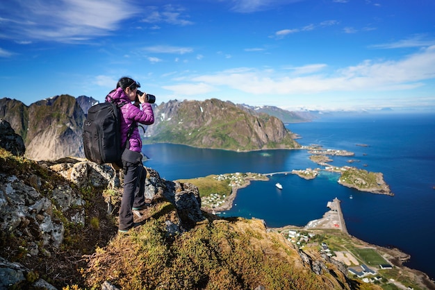 Touriste photographe de la nature avec des prises de vue en se tenant debout au sommet de la montagne. Belle Nature Norvège archipel des Lofoten.