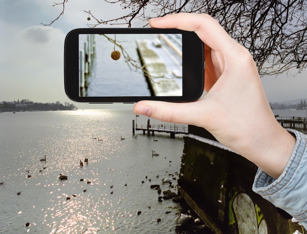 Touriste prenant une photo du lac Léman en hiver