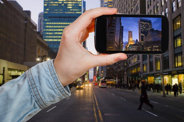 Touriste prenant la photo de New York City dans la nuit