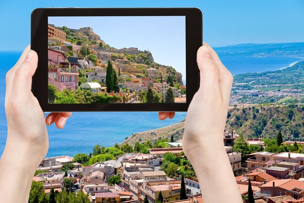 Photo touriste prenant la photo de la ville de taormina