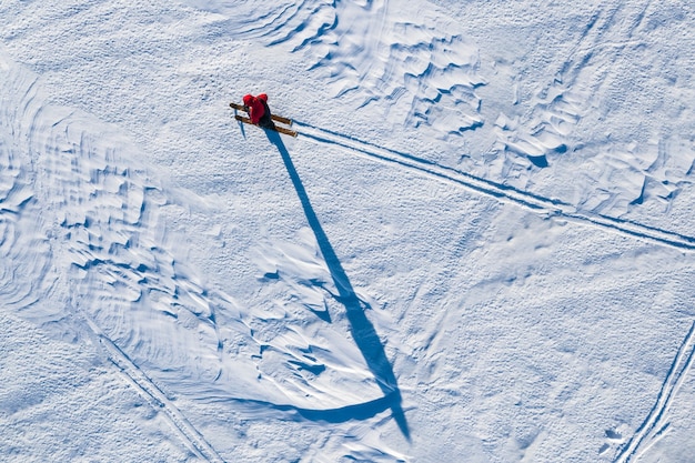 le touriste se déplace sur des skis sur un champ enneigé en hiver est retiré de l'hélicoptère par le haut