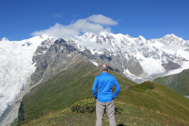 Le touriste se tient à la surface d'un paysage montagneux